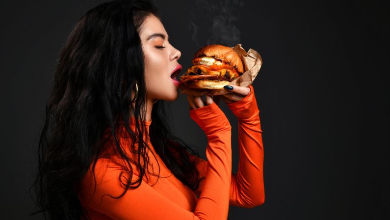 Woman eating hot spicy chicken sandwich